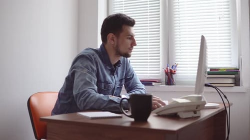Junger Geschäftsmann arbeitet am Computer in einem stilvollen modernen Büro