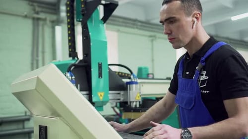 Um operário está parado no painel de controle