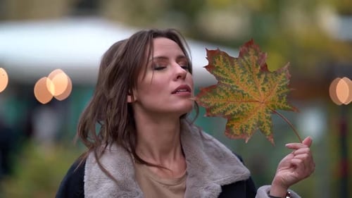 Close-up Portrait of a Young Woman Listening To Music with Headphones in the Open Air. She Walks on