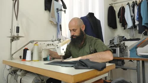 Man Using Sewing Machine in Brightly Lit Workshop