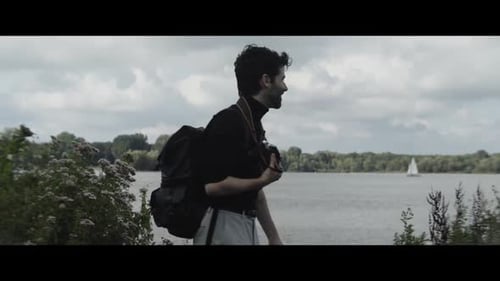 Man taking pictures of the lake and smiling