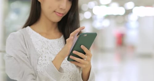 Woman using cellphone in the station