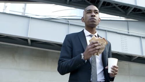 Young Adult Eating Sandwich in City