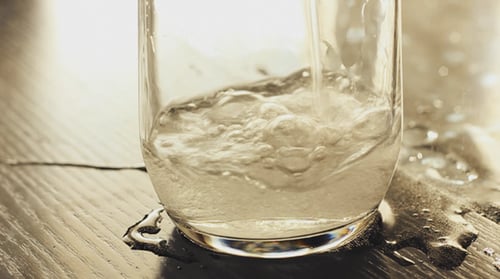 Mineralwasser ins Glas gießen