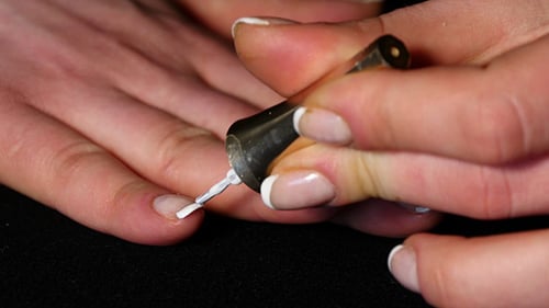 Woman Applying White Nail Polish for French Manicure