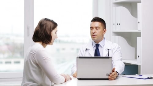 Smiling Doctor And Young Woman Meeting At Hospital