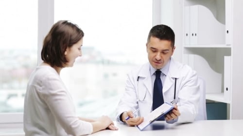 Smiling Doctor And Young Woman Meeting At Hospital