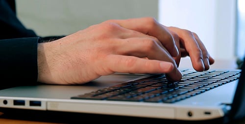 Hands Typing on Laptop Keyboard Close Up