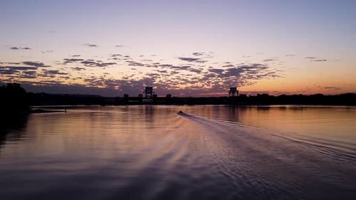 Motorboat Glides on Tropical Lake at Sunset