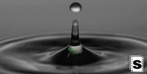 Water Drop Creates Ripples in Dark Liquid
