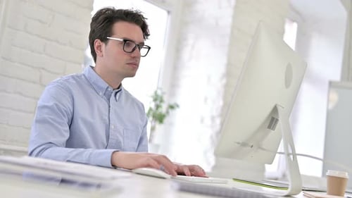Überrascht arbeitender junger Mann fühlt sich im Büro schockiert