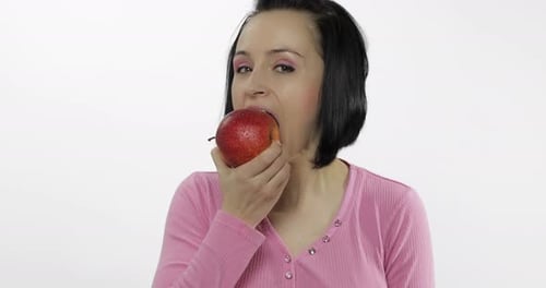 Woman Eating Red Apple in Front of White Background