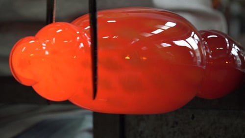 Shaping Molten Glass Art Piece with Precision Tools