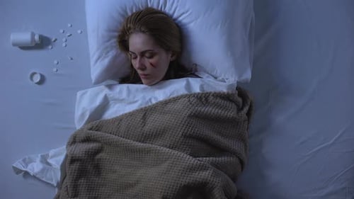 Woman Sleeps in Bed With Pills Beside Her