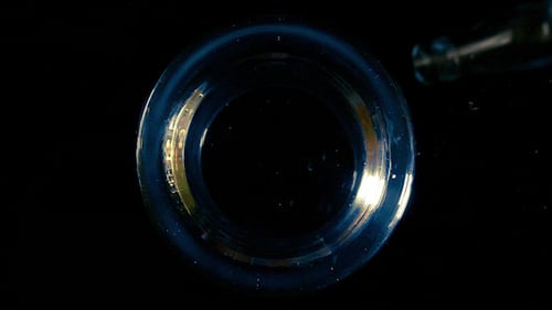 Close Up Pouring Liquid into Circular Glass