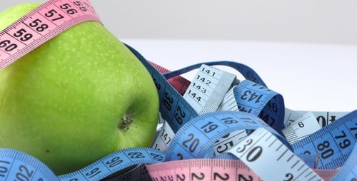 Green Apple Surrounded by Colorful Measuring Tape