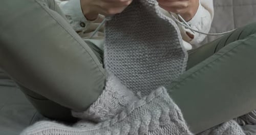 Woman Knitting Cozy Grey Fabric on Bed