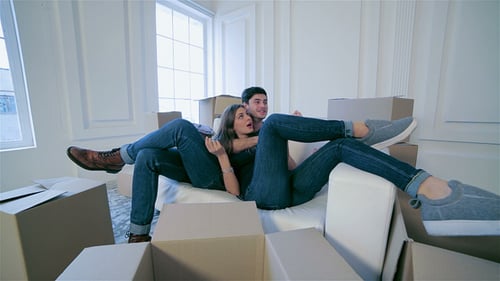 Verliebtes Paar umarmt sich liegend zwischen den Kisten