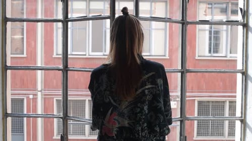 slow motion young woman indoors opening window stretching arms