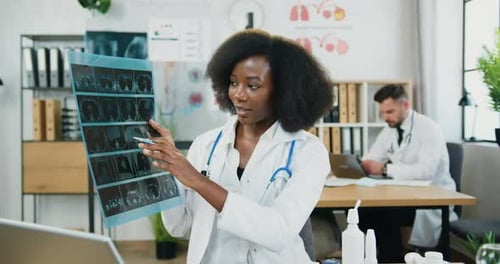 Trabajadora médica de piel negra explicando los resultados de la radiografía ante la cámara