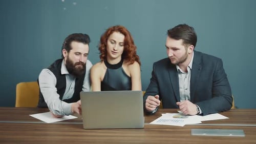 Team Meeting at Conference Table with Laptop