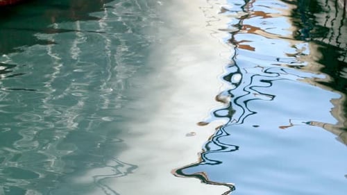 Water Ripples Reflecting Urban Landscape on Canal