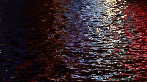 Rippling Water Reflecting Colorful City Lights at Night