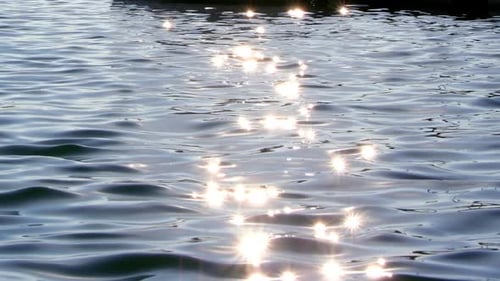 Weiches, fokussiertes Funkeln des Lichts, das auf Wasser reflektiert wird