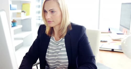 Woman Working on Computer at Desk in Office