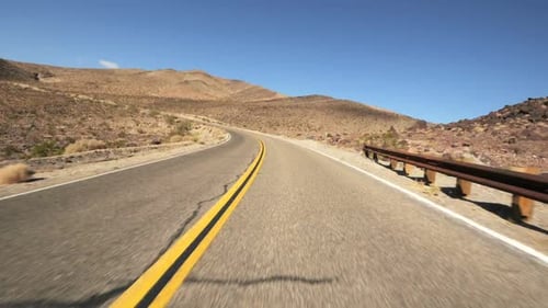 Driving Along a Desert Road on a Sunny Day