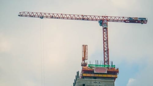 Construction Crane Lifting Supplies at Building Site