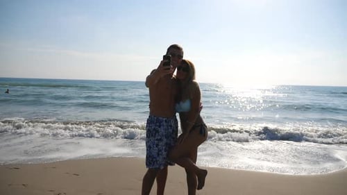 Smiling Couple Taking Self Photo Posing on Coast. Happy Traveling Pair Making Photography at Ocean