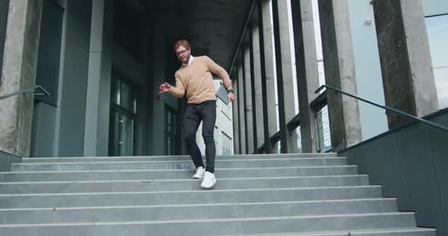 Joven feliz bailando activamente mientras camina por las escaleras.
