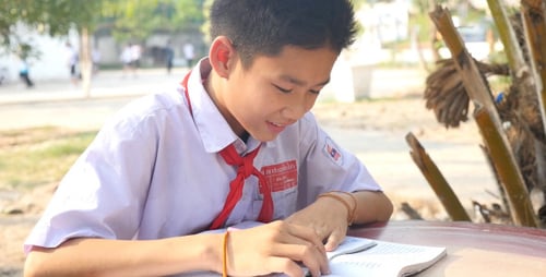 Diligent Student Reading and Writing Outdoors