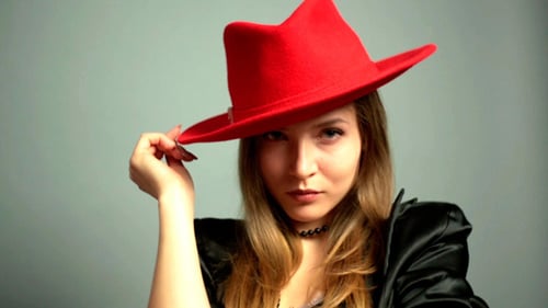 Stylish Young Woman Posing with a Red Hat