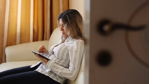 Young Woman Using Tablet on Couch Indoors