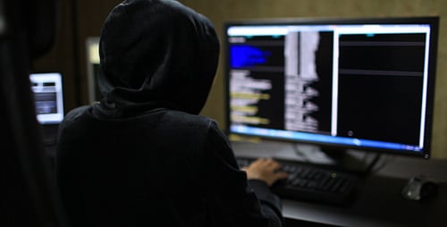 Person in Hoodie Typing on Computer Keyboard