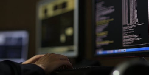 Hands Typing on a Computer Keyboard at Night