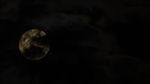 Dramatic Moon Obscured by Clouds at Night