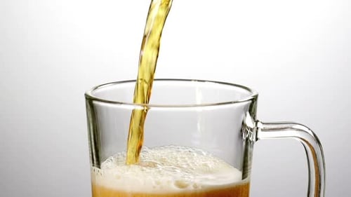 Refreshing Beer Poured Into a Glass Mug