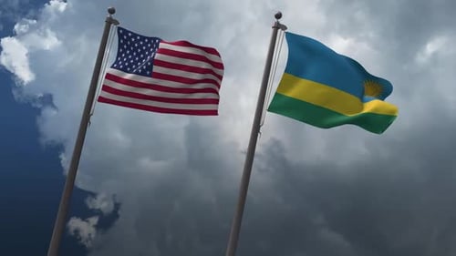 USA and Rwanda Flags Waving on Flagpoles Against Cloudy Sky