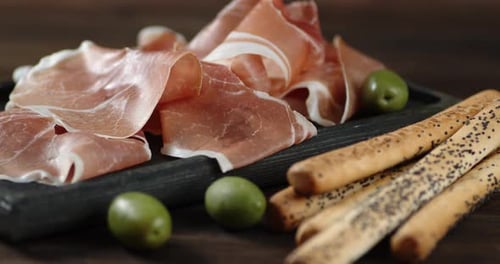 L'antipasto aux olives sur la planche à découper tourne lentement.