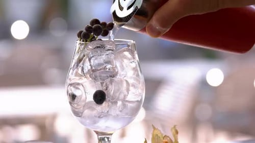 Beverage Poured into Glass with Ice and Blueberries