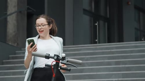 Woman Using Electric Scooter in City