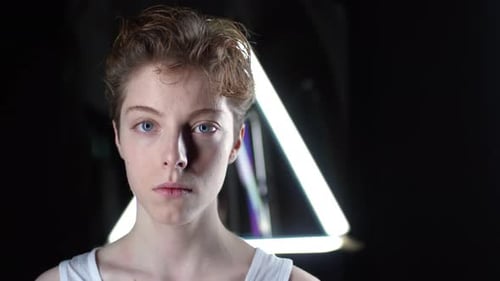Young Adult Posing in Front of Neon Lights