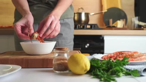 Hands Peeling Fresh Shrimp in Kitchen Close Up