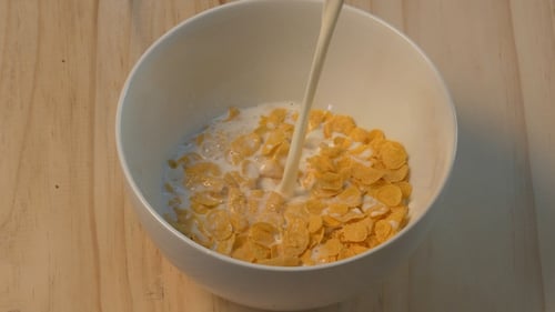 Pouring Milk onto Cereal in Bowl