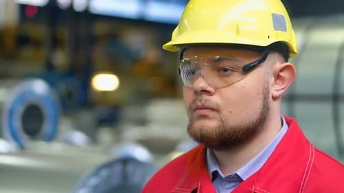 Engineer in Hardhat is Moving Through a Heavy Industry Factory