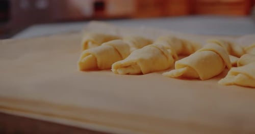 Femme préparant de délicieux croissants sur la table dans la cuisine