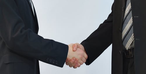 Two Men in Suits Shake Hands in Agreement